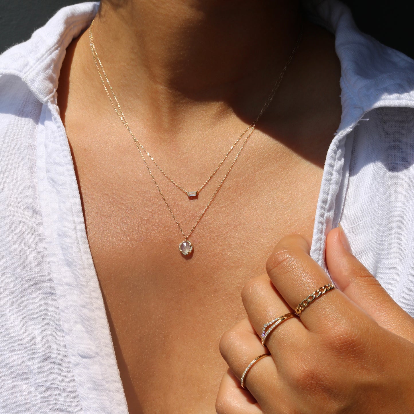 diamond and moonstone necklace layered with a 14k gold white topaz pendant, both solid gold pieces with gemstones