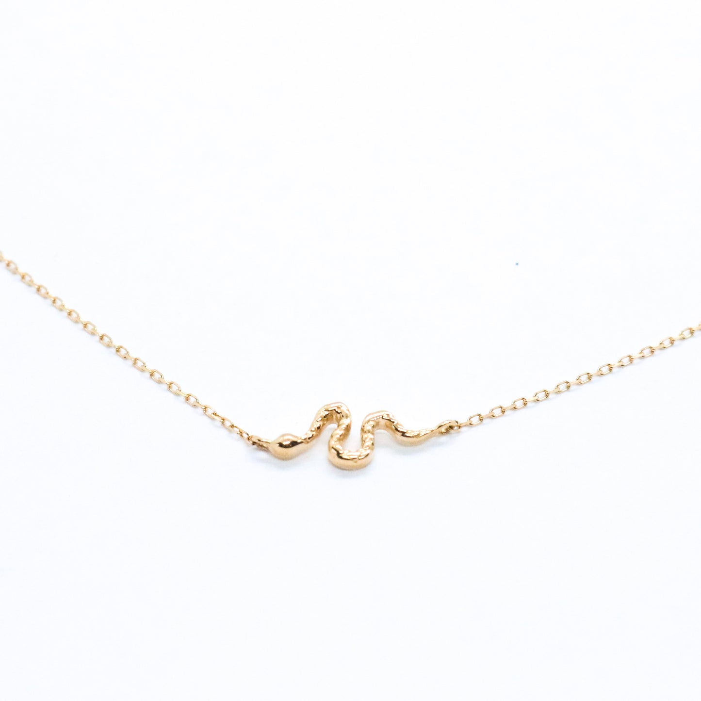 a close up of a serpent snake 14k gold necklace