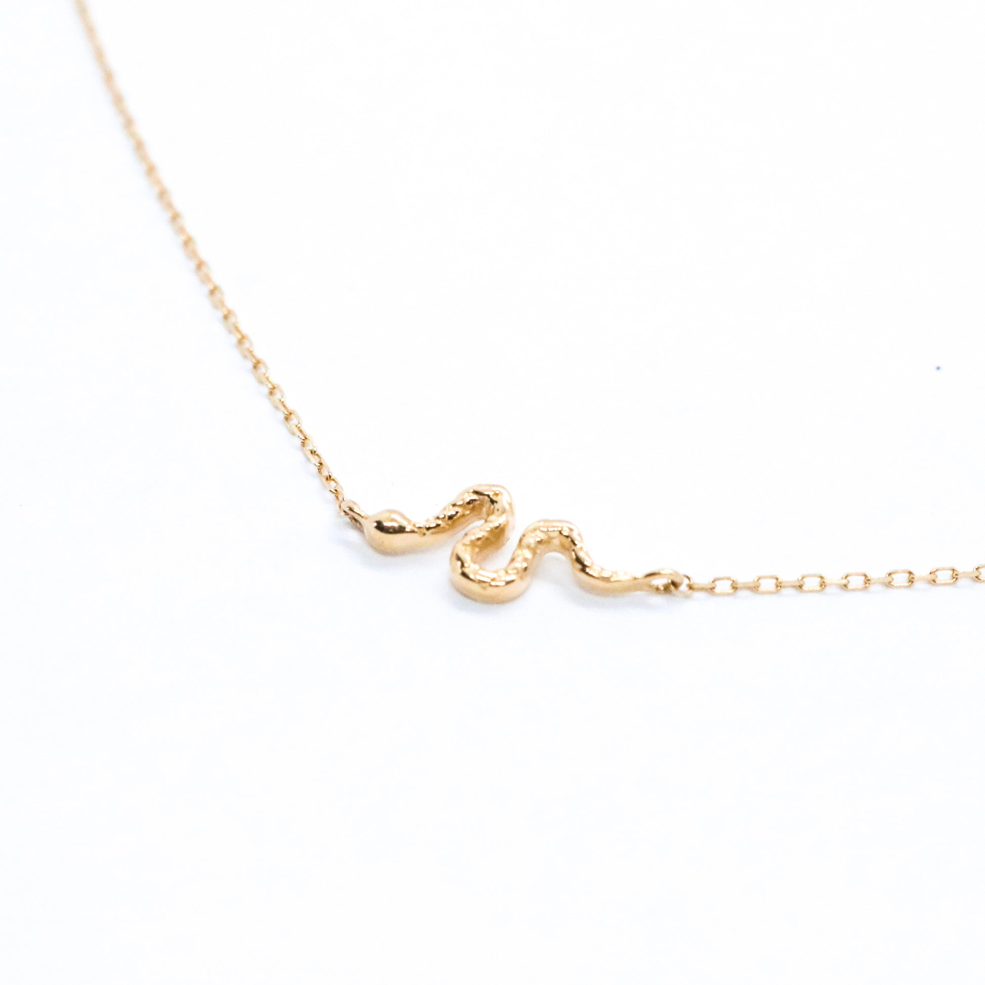 solid 14k gold serpent snake necklace on a white background